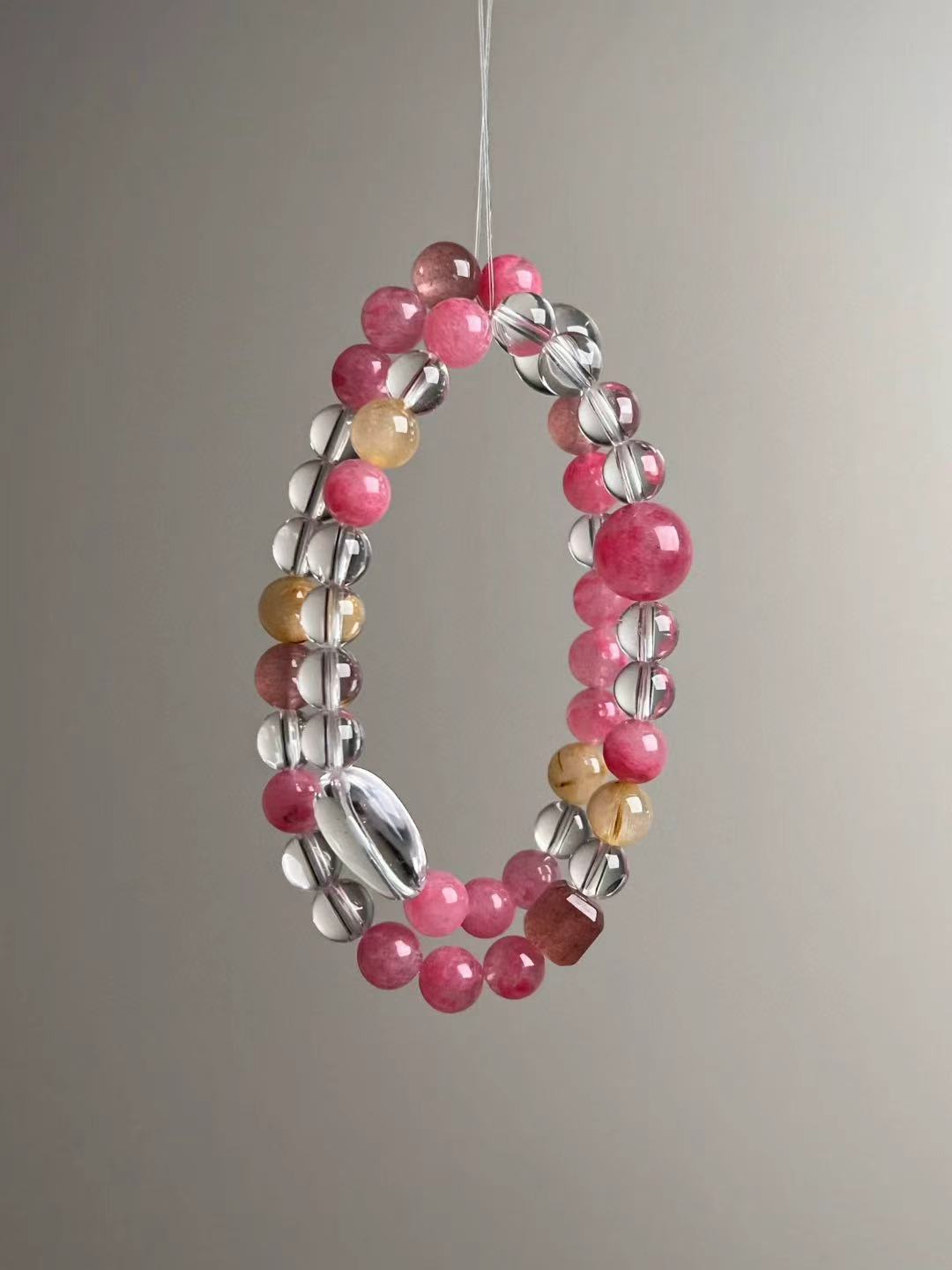 Full loop display—slender profile of the bracelet showing Clear Quartz oval focal and evenly spaced pink gemstones
