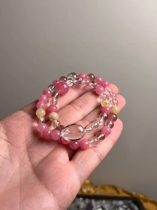 On-hand photo—11.5–7 mm bracelet with Clear Quartz oval focal, Rose Quartz, Golden Rutilated Quartz and Strawberry Quartz