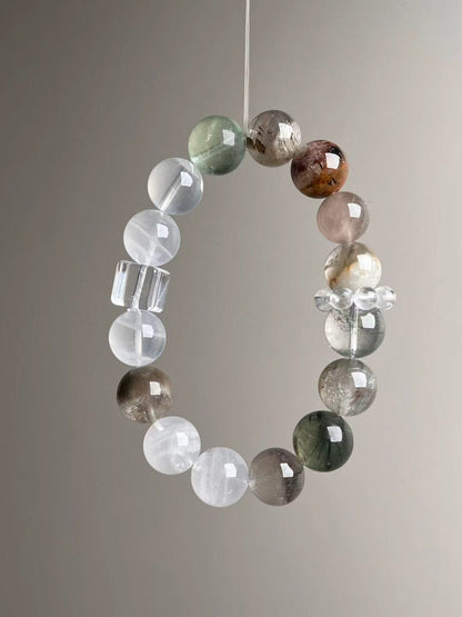 Close suspended loop emphasizing layered phantom structures; clear-quartz runner ring visible.