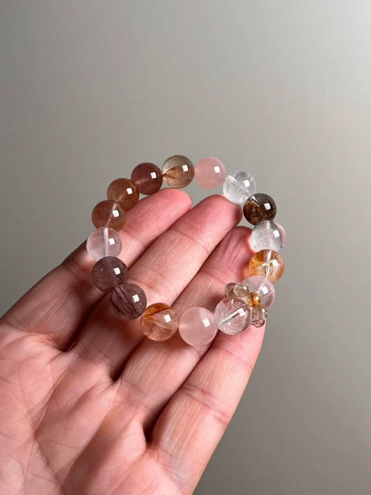 On-hand photo—12 mm bracelet with White Phantom Quartz, Golden Garden (lodolite) Quartz, rutilated varieties and Rose Quartz, plus multicolor rutile bead-cluster runner