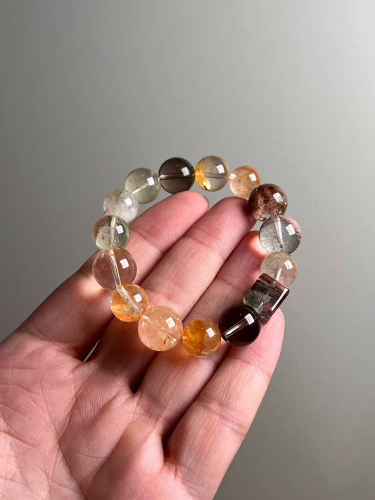 On-hand photo—12–14.5 mm bracelet with Yellow Azeztulite, Smoky Quartz, Red & Green Phantom Quartz and a rainbow phantom cube; yellow bead-cluster spacer