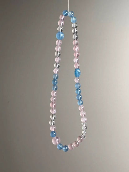 Suspended loop view showing alternating rose quartz and aquamarine rounds with clear-quartz spacers in a soft pastel palette.