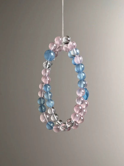 Close three-quarter view highlighting luminous aquamarine blues next to blush-pink rose quartz rounds