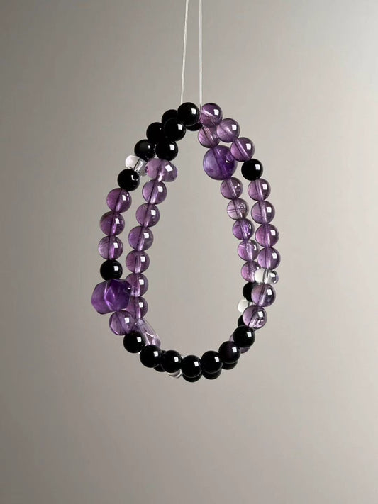 Suspended set view showing two loops of amethyst rounds, glossy black obsidian beads and clear quartz spacers