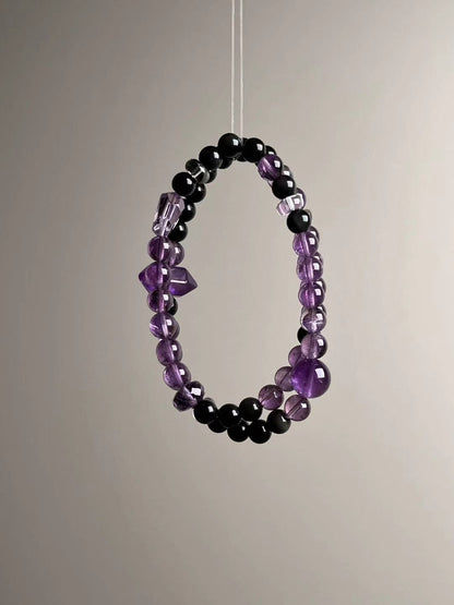 Full-length loop showing the double-wrap strand layout with even spacing of obsidian and clear quartz