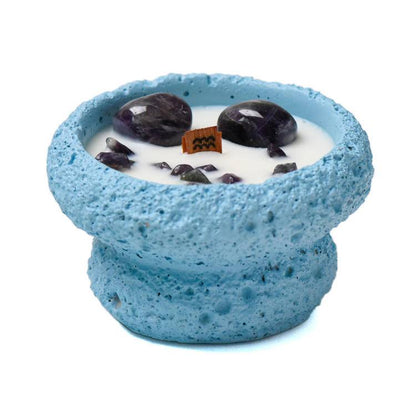 Aquarius candle close-up in sky-blue vessel with amethyst stones and crackling wooden wick symbol tag.