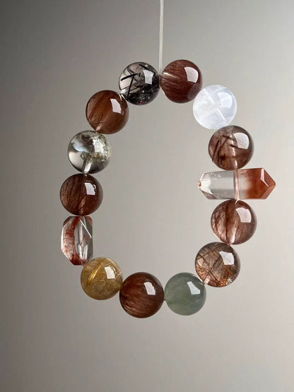 Side angle of copper rutile bracelet showing double-terminated red hair quartz focal bead