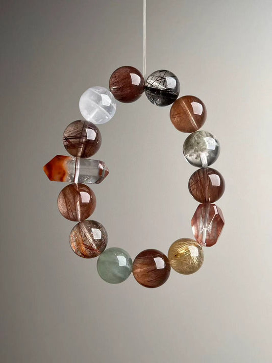 Detail of mixed hair quartz and phantom quartz beads in warm earth tones on luxury stretch bracelet