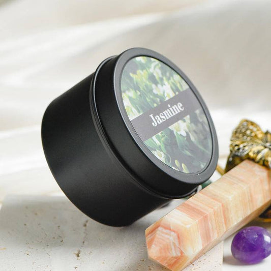 Closed black travel tin candle labeled Jasmine, minimal matte finish.
