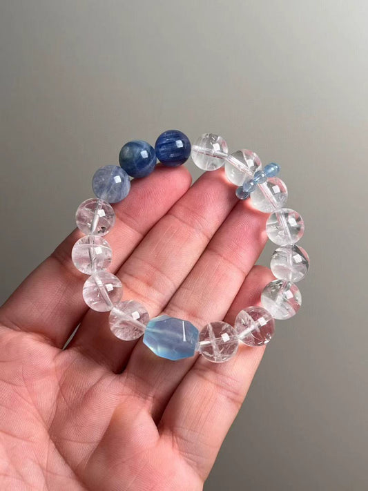 Hand shot of the Ocean Sanctuary bracelet—white phantom quartz, kyanite and aquamarine runner beads, ~12 mm rounds with ice-clear clarity.