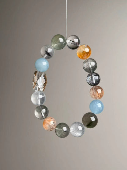 Prosperity Matrix bracelet hanging display with faceted garden quartz focal and golden rutile highlights.