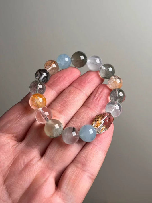 Prosperity Matrix bracelet — golden rutilated quartz, citrine, gray and orange moonstone mix in a tapered 14–11 mm design, shown on hand.